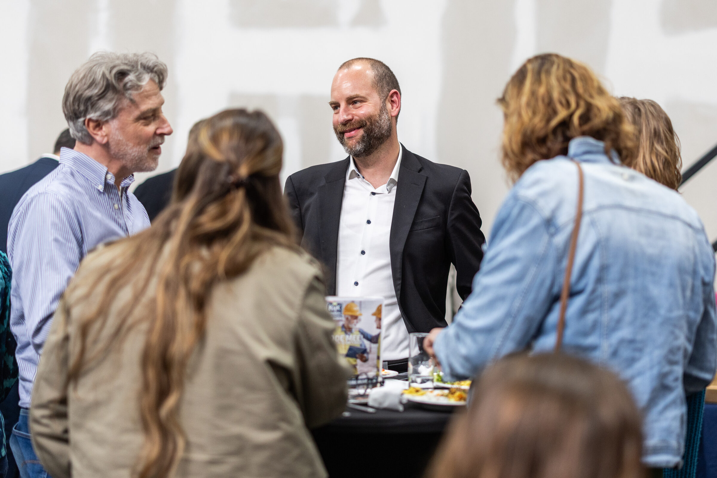 Rene Bakker in gesprek met bezoekers tijdens een netwerkbijeenkomst.
