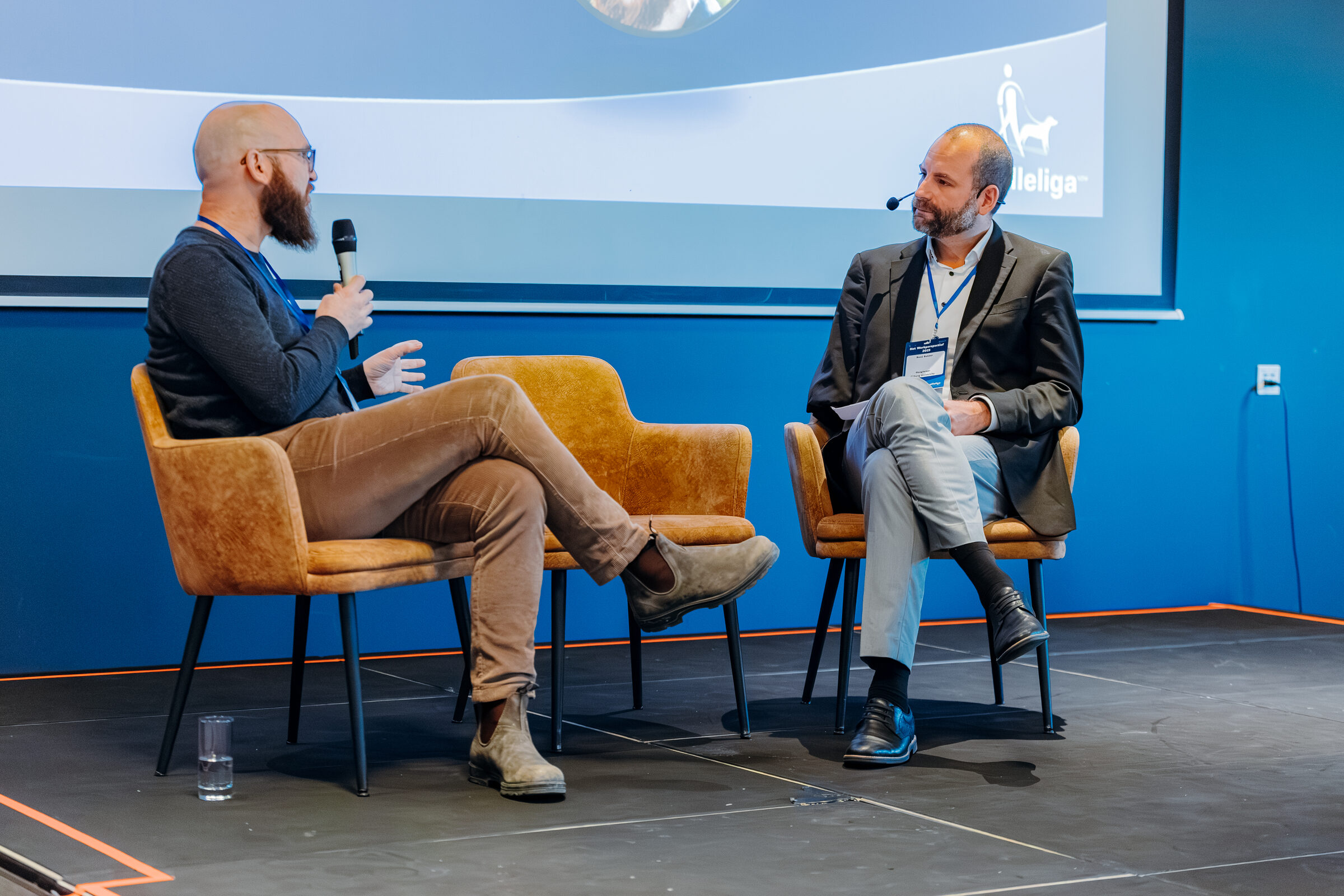 Rene Bakker in gesprek op een podium tijdens een evenement.